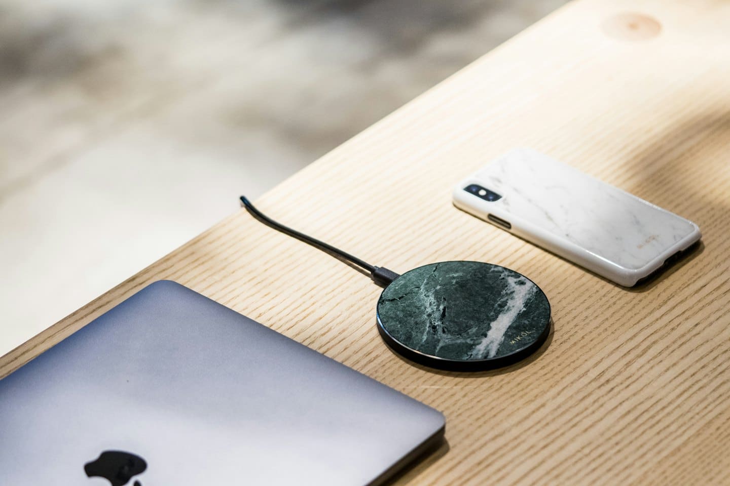 Accessori tecnologici moderni su una scrivania di legno chiaro.