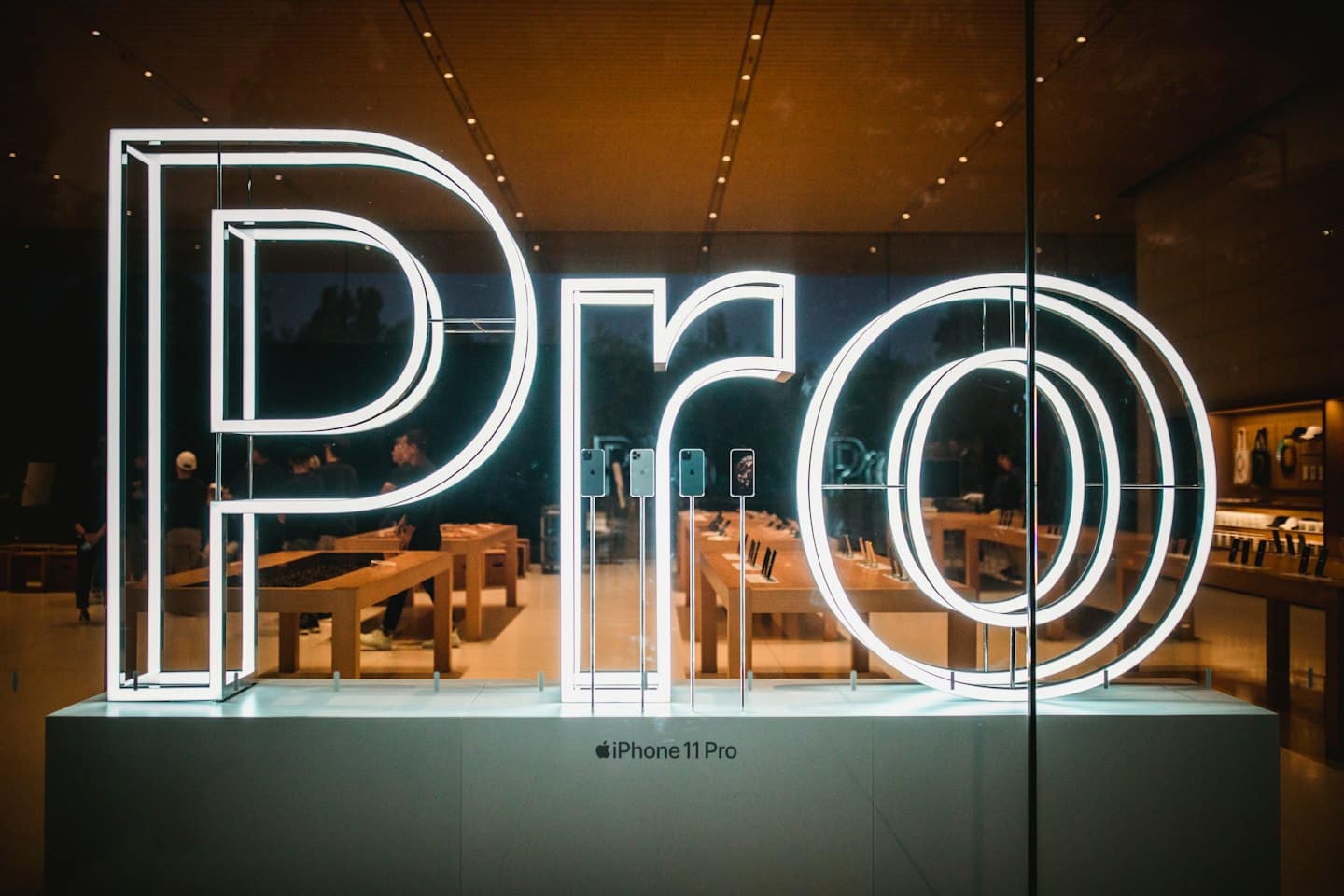 Insegna 'Pro' in vetrina con smartphone in esposizione.